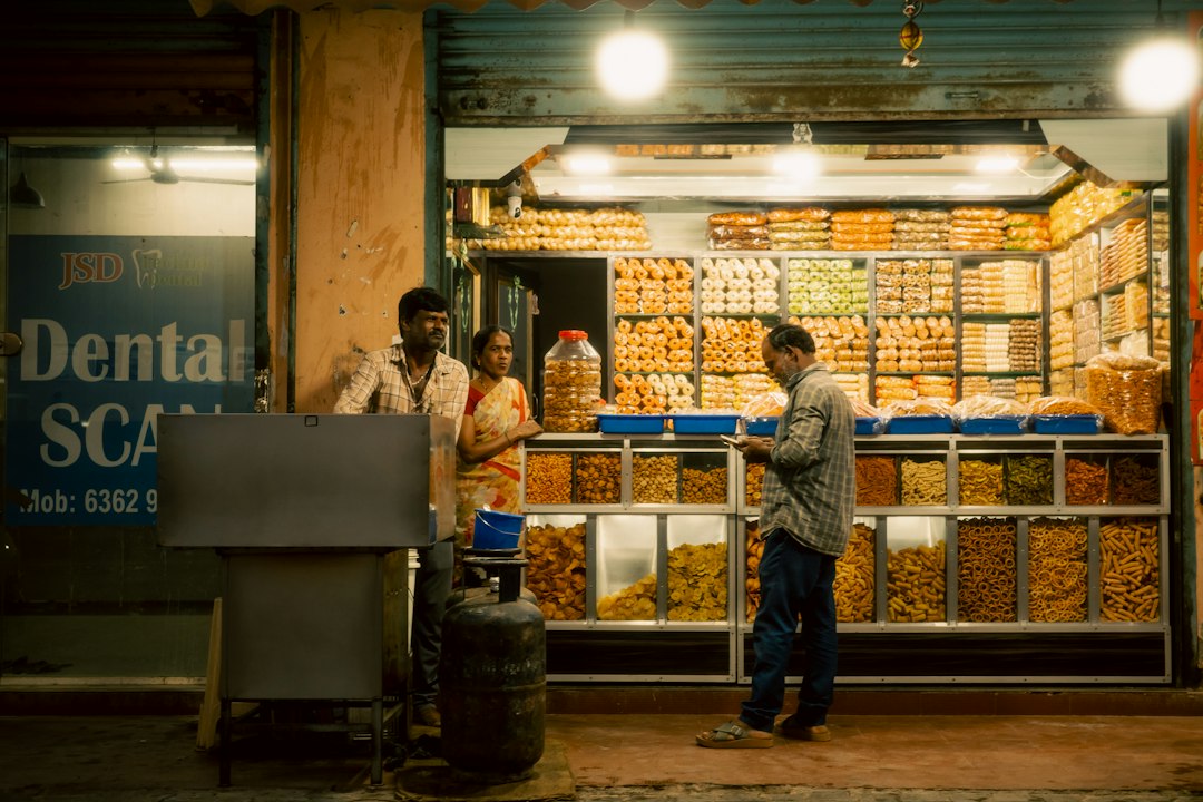 People at a brightly lit street food stall at night